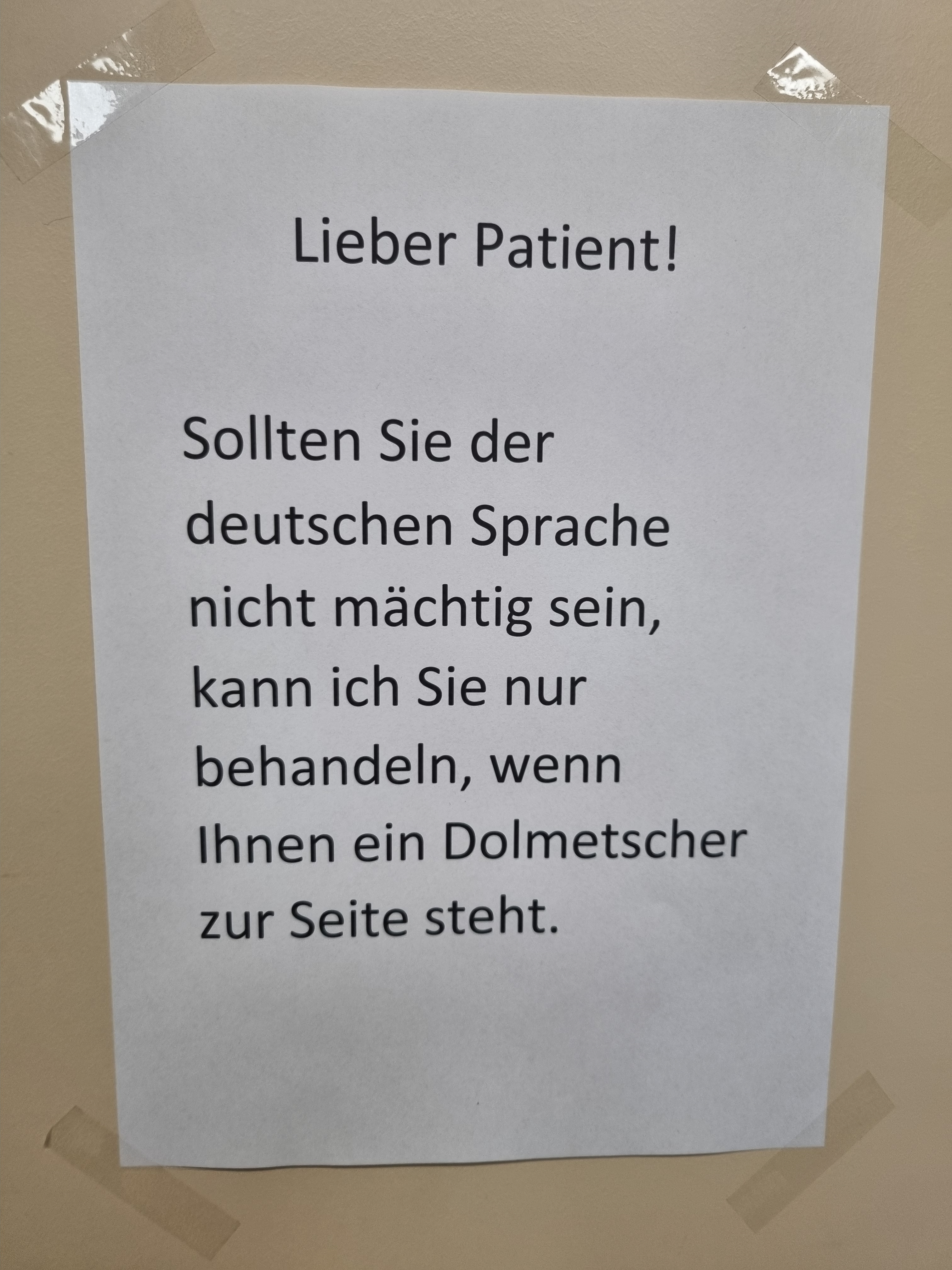 Ein Zettel auf dem steht: Lieber Patient! Sollten Sie der deutschen Sprache nicht mächtig sein, kann ich Sie nur behandeln, wenn Ihnen ein Dolmetscher zur Seite steht.